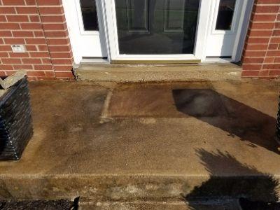 A concrete porch before being pressure washed.
