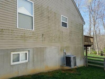 A home with beige siding before being pressure washed.