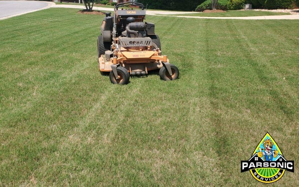 A Parsonic Services lawn mower sitting of a freshly mowed lawn after a lawn mowing service.