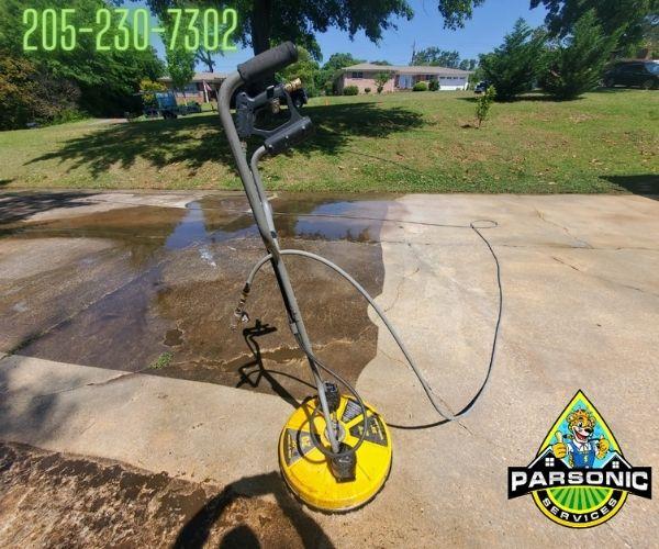 A driveway in the process of being power washed.