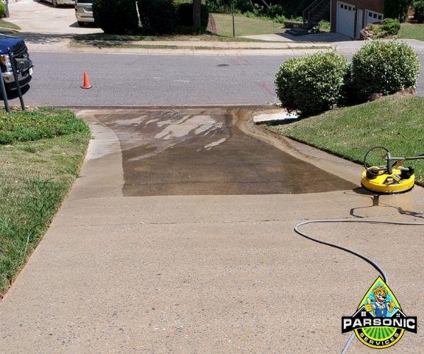 A driveway in the process of being power washed.
