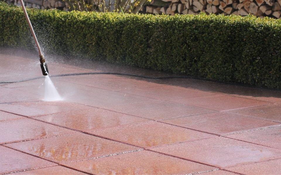 A close up of a driveway being pressure washed.