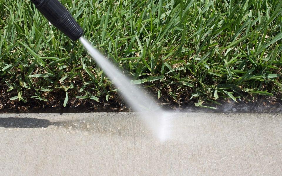 A closeup of a side walk being pressure washed.